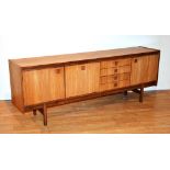 A Retro teak sideboard circa 1960's, with four drawers, flanked by three panelled doors,