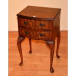 A reproduction mahogany bedside cabinet, with two drawers, raised on cabriole supports and pad feet,