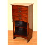 An Edwardian mahogany music cabinet, with four drawers above open shelved recess,