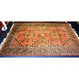 A Persian floor rug, decorated with geometric medallions and motifs on orange,