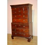 A George III oak chest on chest, the top section with two short above three long graduated drawers,