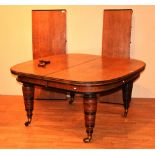 A Victorian oak telescope dining table, with two additional leaves, raised on ring turned supports,