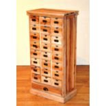 A stripped wood apothecary chest of drawers, with eight sets of three index type drawers,