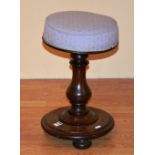 A late Victorian mahogany revolving piano stool, raised on turned column and circular platform base,