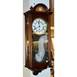 A Vienna wall clock by Comitti of London, with glazed door enclosing dial with Roman numerals,