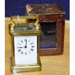 A brass carriage clock, with single train movement and white enamel dial, with carry handle,