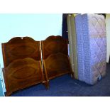 A pair of Queen Anne style walnut single beds, with later bases, mattresses and irons,