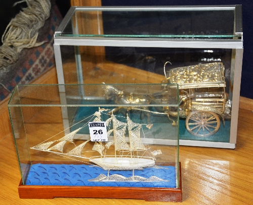 A silver filigree model of a ship, 12cm high x 19cm diameter, in glass display case,