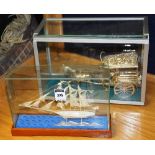 A silver filigree model of a ship, 12cm high x 19cm diameter, in glass display case,