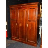 An Edwardian mahogany inlaid three door wardrobe, decorated with satinwood inlaid crossbanding,