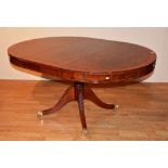 A reproduction 'drum' dining table in the regency manner, with spare leave,