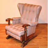 A Vintage rocking armchair, upholstered in striped fabric,