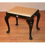 A black Japanned dressing stool in George II style, raised on cabriole supports, and pad foot,