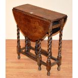 An oak gateleg table of small form, with drop leaves, raised on barley twist supports,