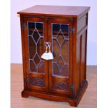 An oak effect Hi-Fi cabinet, with two glazed leaded doors,