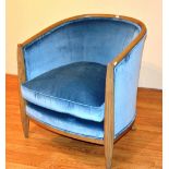 A contemporary light oak framed tub armchair, upholstered in pale blue velour,