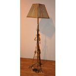 An Art nouveau brass adjustable floor lamp and shade, with stylized decoration,