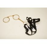 A vintage gold plated lorgnette, with black ribbon attachment,