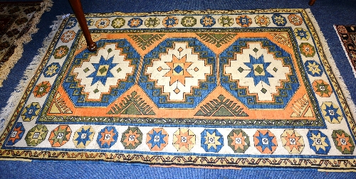 A Persian style rug, decorated with three central geometrical medallions and similar border, blue,