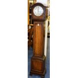 An oak granddaughter clock, with silvered dial above panelled trunk,