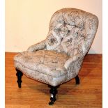 A late Victorian upholstered nursing chair, raised on turned ebonised supports, with brass castors,