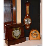 A stained wood mantel clock, with brass winged surmounts and silvered dial, 33cm high x 34cm wide,