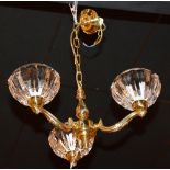 A brass three branch electrolier, with three heavy glass fluted shades,