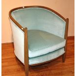 A contemporary light oak framed tub armchair, upholstered in pale green velour,