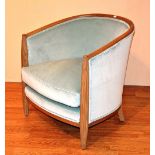 A contemporary light oak framed tub armchair, upholstered in pale green velour,