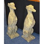 A pair of garden stoneware dog figures, in upright positions,