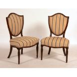 A pair of George III mahogany chairs, circa 1785, with shield-shaped later upholstered backs,