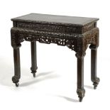 A Chinese ebonised centre table, decorated with carved foliate and fern panels,
