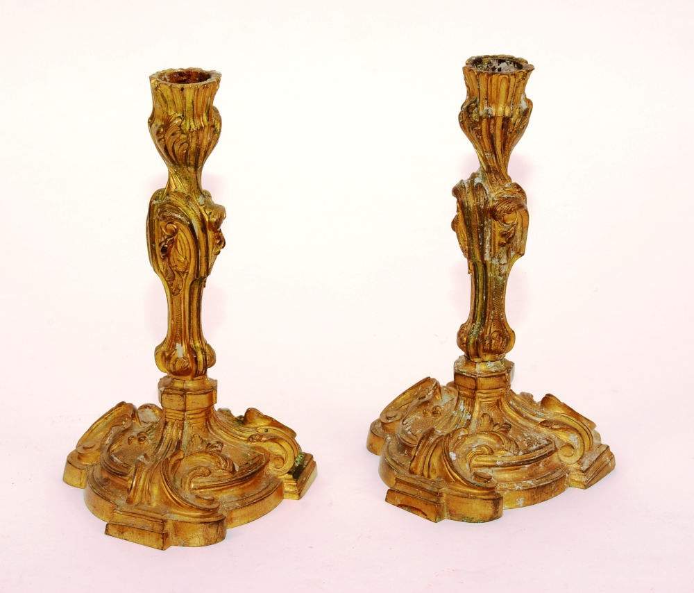 A pair of small French Rococo ormolu candlesticks,