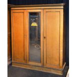 A Victorian pine three door wardrobe, to include mirrored door,