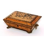 A Regency penwork workbox, with side ring-handles and paw feet, lacking interior,