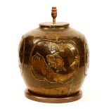 A 19th century Korean pottery vase lamp, with animal decoration on brown glaze, raised on wood base,