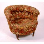 An Edwardian buttoned low tub chair, circa 1910, with floral upholstery and tapering mahogany feet,