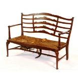 A mahogany parlour settee, circa 1890, in the manner of Wylie and Lochhead, Glasgow,