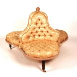 A central conversation seat, of clover leaf form, with buttoned back and seat,