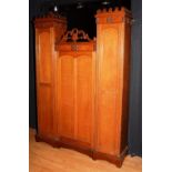 A Victorian pale oak cupboard, circa mid 19th century, the side sections with castellated tops,