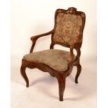 An Italian walnut open armchair, circa 18th century, with needlepoint upholstery,