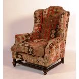 A Kelim covered wing armchair, circa 1900, with bobbin-turned legs and stretchers,