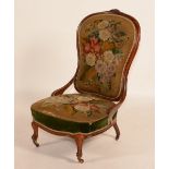 A Victorian walnut low chair, circa mid 19th century, with needlework covered back and seat,