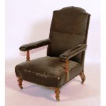 A Victorian low armchair, raised on turned supports,
