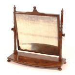 A Regency mahogany dressing glass, circa 1820, with rectangular plate and bowed base,