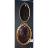 Two modern oval wall mirrors,