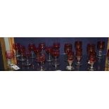 Eleven matching cranberry glasses, raised on plain stem and circular foot, 12cm high,