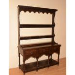 A George III style oak welsh dresser, with shelved Delft rack above three drawers and undertier,