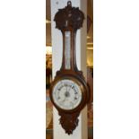 An Edwardian carved oak aneroid banjo barometer by James Ballantyne & Son Glasgow,