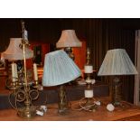 Four ornate brass coated table lamps, two with shades,
